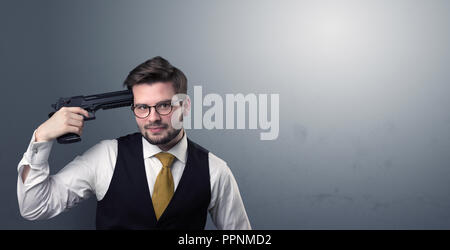 Young lost businessman man shooting his head with gun Stock Photo