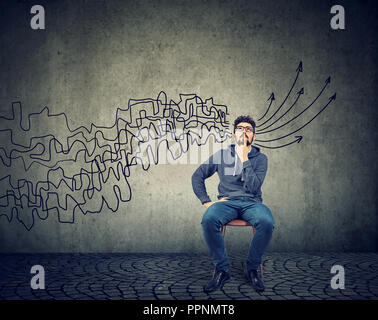 man looking up brainstorming getting his thoughts together planning making conclusions isolated on gray wall background Stock Photo