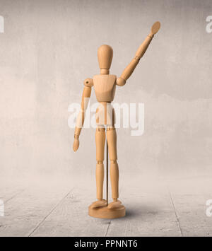 Wooden mannequin posed in front of a greyish background Stock Photo