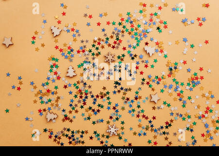 Festive colorful stars of confetti on a yellow background. Stock Photo