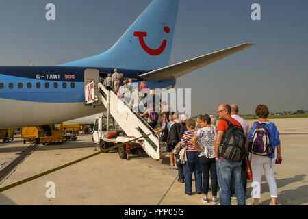 Passengers climbing the stairs to board their TUI holiday jet via the rear door. Stock Photo