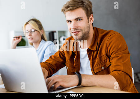 happy colleagues working on startup project in office with laptop Stock Photo
