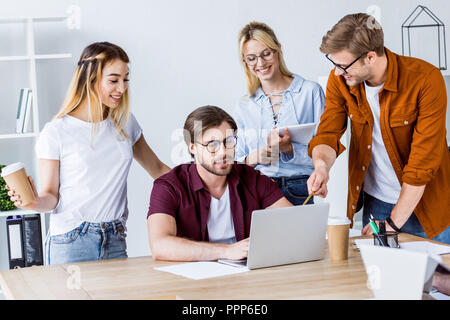multicultural colleagues working on startup project in office and discussing something Stock Photo