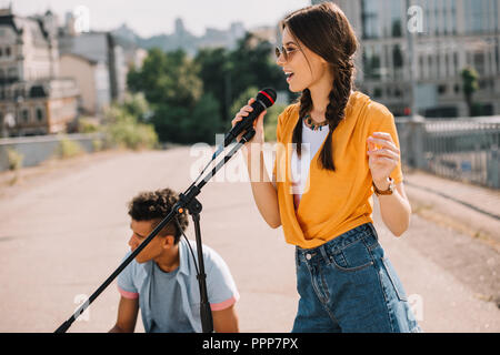 Young and happy street male and female musicians performing in city Stock Photo