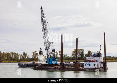 Floating crane and barge dredging the Steveston waterway near Vancouver Stock Photo