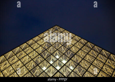 Night glass pyramid in dark blue sky background, Paris, France.