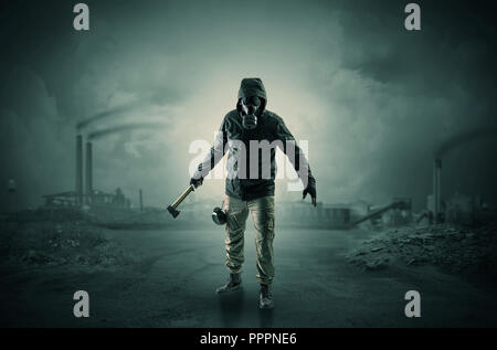 Gas masked survival man coming with arms on his hand  in a demolished dark environment   Stock Photo