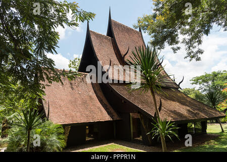 June 5, 2018, Chiang Mai, Thailand: Exterior of oriental building of Baandam Museum with tiled roof under green tree, Thailand Stock Photo