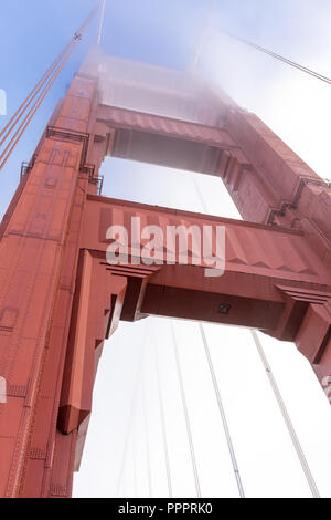 Golden Gate Bridge tower in the fog, looking up from the base. Stock Photo
