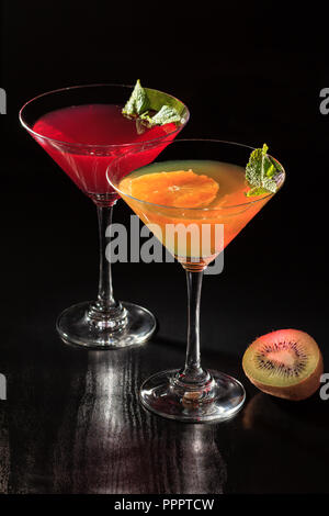 Cherry and orange jelly with lime pieces in the glasses topped mint leaves on the black background Stock Photo