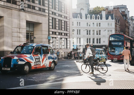 London, UK - September 17, 2018: Businessman on a bicycle waiting for traffic to pass on a street in the City of London, London, UK, London's famous f Stock Photo