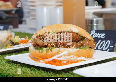 The paper coaster with Vietnamese variation of the burger, bread, lamb meat and the fresh vegetable. Stock Photo