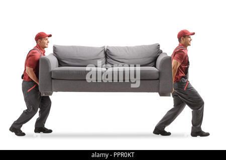 Full length profile shot of two movers carrying a couch isolated on white background Stock Photo