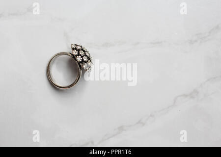 silver ring with precious stones on the marble background Stock Photo