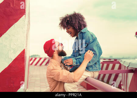 Handsome man wearing red glasses and his girlfriend smiling while looking at him Stock Photo