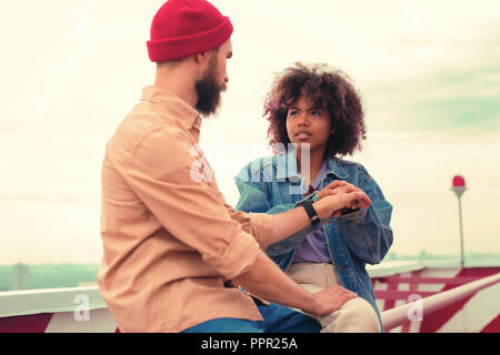 Young girl having unpleasant talk with her boyfriend and holding his hand Stock Photo