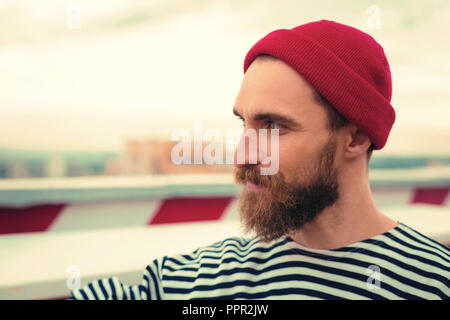 Confident bearded man smiling while looking into the distance Stock Photo