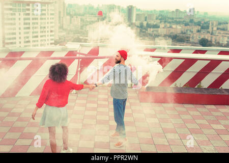 Creative young making surprise for his girlfriend with smoke flare Stock Photo
