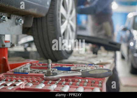 Mechanic tools lie next to the car's wheel on repair Stock Photo