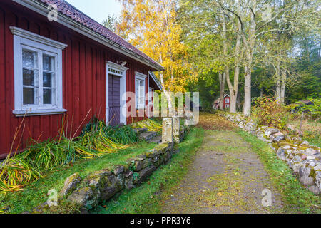 Detached rural red countryside house with pitched roof by a river with ...