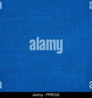 Fabric of blue color for warm autumn dress or skirt.On the fabric is a picture in the form of black rhombus Stock Photo