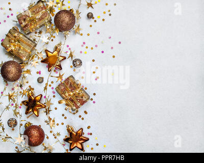 Round fur-tree toys, Christmas tree-shaped toys, multicolored confetti, golden twisted garland on a white textural background horizontally with copy s Stock Photo