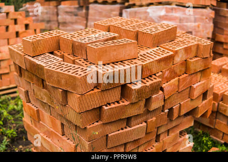 Stack of red brick for construction. Common quality building bricks stacked ready for use. Stock Photo