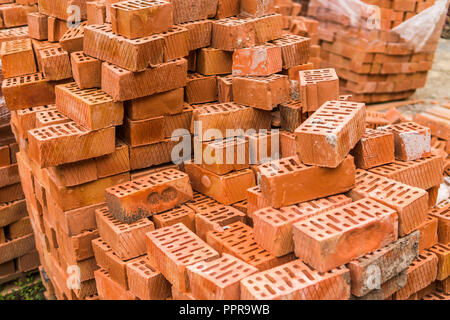 Stack of red brick for construction. Common quality building bricks stacked ready for use. Stock Photo