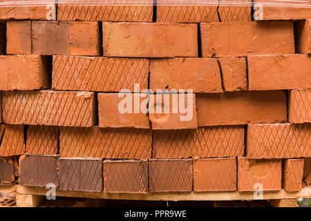 Stack of red brick for construction. Common quality building bricks stacked ready for use. Stock Photo