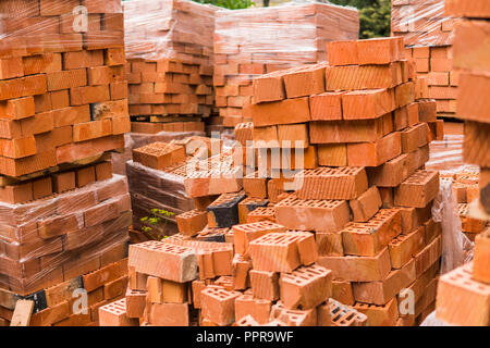 Stack of red brick for construction. Common quality building bricks stacked ready for use. Stock Photo