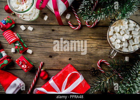 Classic Christmas background, xmas tree ornaments and branches, children's new year toys, candy canes, pine cones, santa hat and gift boxes on old woo Stock Photo