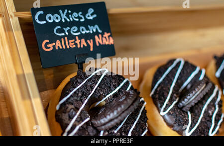 a close up shot of chocolate cookie doughnuts on display for sale Stock Photo