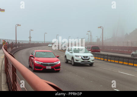 Light traffic on the Golden Gate Bridge on a foggy morning, San Francisco, California, United States Stock Photo