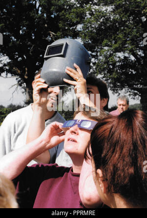 Eye protection -  August 1999. A Total Solar Eclipse is imminent in Hampshire UK and all means of eye protection, including a welder's mask, are used. Stock Photo