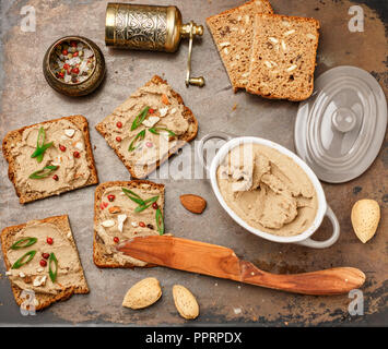 Fresh homemade chicken (duck, goose, rabbit, Turkey) liver pate with almonds, pink pepper and green onions on whole grain bread with seeds.  Tradition Stock Photo