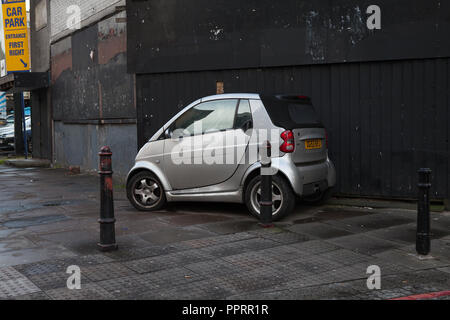 Smart car parked on a pavement. Stock Photo