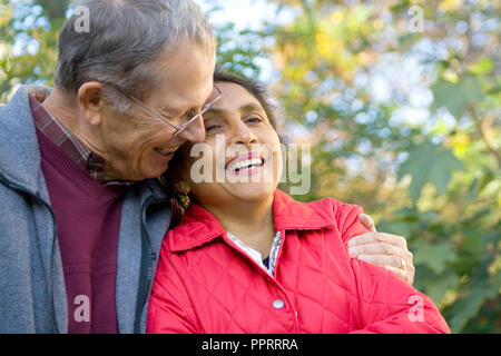 White senior husband lovingly embraces his new Indian (India) wife. St Paul Minnesota MN USA Stock Photo