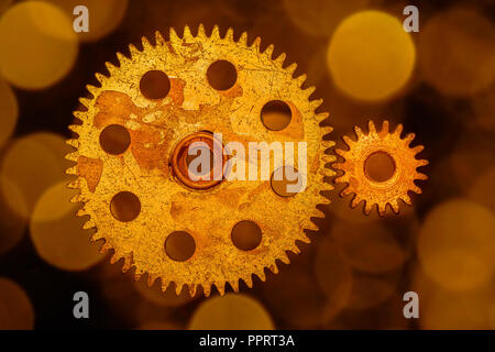 Golden cogwheels  on a background of gold circeled bokeh. Stock Photo