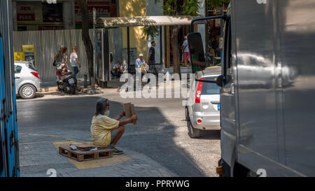 Athens Greece/August 17, 2018: Woman walking down closed down flea market with graffiti on the closed doors Stock Photo