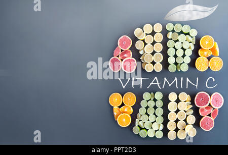Many citrus fruits in the shape of a sliced fruit icon with vitamin c handwritten inside Stock Photo
