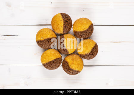 Group of seven whole fresh baked marble muffin flatlay on white wood Stock Photo