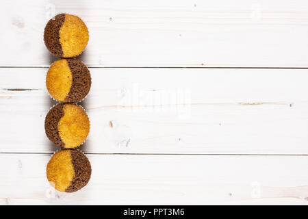 Group of four whole fresh baked marble muffin flatlay on white wood Stock Photo