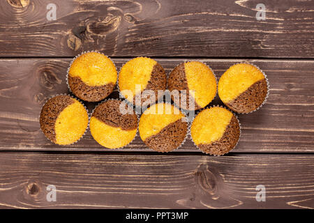 Group of eight whole fresh baked marble muffin flatlay on brown wood Stock Photo