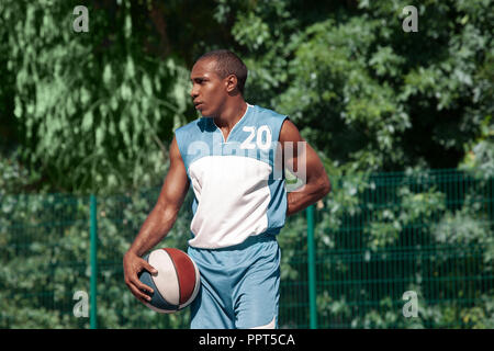 Picture of young confused african basketball player practicing outdoor. Fit afro man resting after movement. athletic and sport lifestyle concept Stock Photo