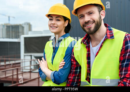 professional engineers in hardhats and safety vests on roof Stock Photo