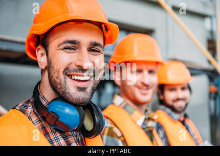 close-up shot of group of equipped builders looking at camera at construction site Stock Photo