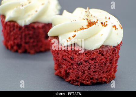 Two delicous Red Velvet cupcakes on black slate base. the image is sharp at the front then softens to the rear of the second or rear cupcake. Good ima Stock Photo