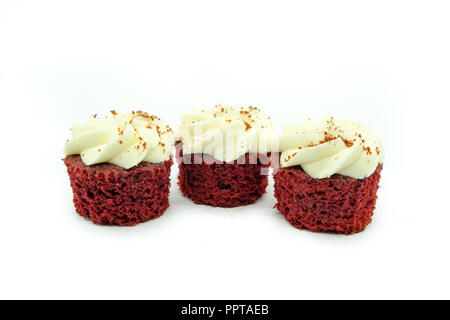 Three beautiful Red velvet Cupcakes in a row on a white background.  The cakes at either end are in focus gowing softer to the rear. Good image for ba Stock Photo