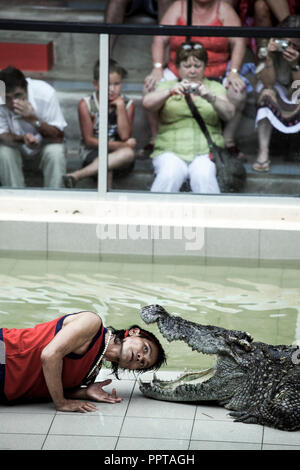 Thai man puts his head inside crocodiles mouth during a show in Phuket, Thailand Stock Photo