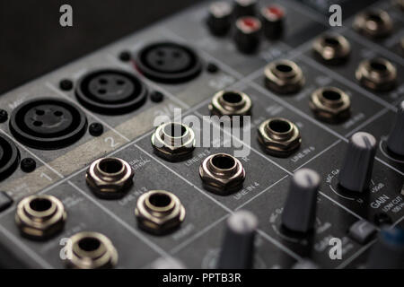 rows of silver gold  audio input connectors, on a professional audio mixing console/ desk Stock Photo